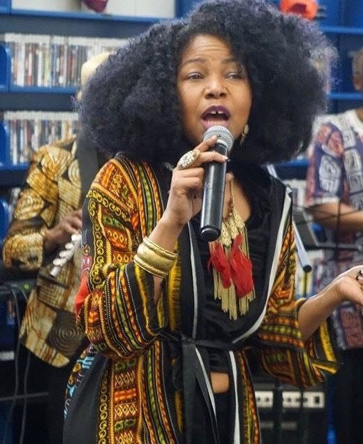 Stacia Hobdy singing with a microphone
